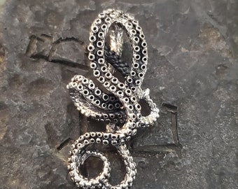 May include: A silver octopus pendant with a detailed design of tentacles and suction cups.