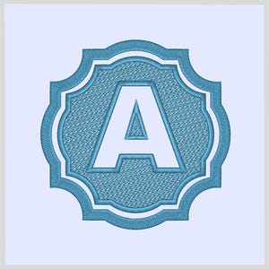 May include: Embroidered letter "A" in a light blue, ornate frame. The letter is white, and the frame has a textured appearance. The design is set against a light blue background, creating a classic monogram style.
