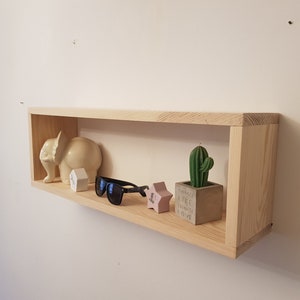 Op de afbeelding: Een houten plank met een wit olifantbeeldje, een zonnebril, twee roze sterren en een kleine cactus in een pot. De cactuspot heeft de tekst "Things I like things I love" erop.