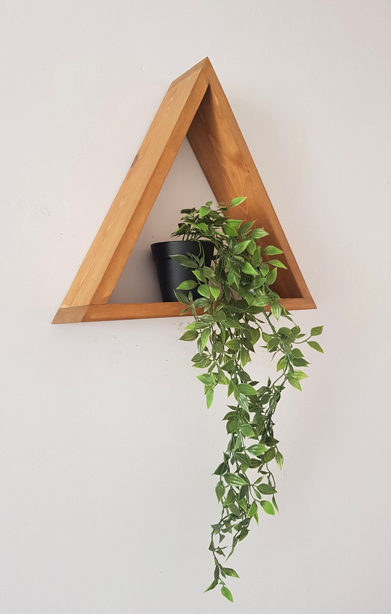 Peut inclure: Une &eacute;tag&egrave;re triangulaire en bois avec une petite plante en pot dessus. La plante pend de l'&eacute;tag&egrave;re.