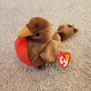May include: Brown and red plush bird toy with a Ty tag that says "Ty Inc. Beanie Babies"