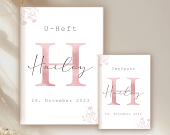 Puede incluir: Dos tarjetas blancas con una letra H rosa en acuarela y el nombre Hailey. La tarjeta más grande dice "U-Heft" y "29. Noviembre 2023". La tarjeta más pequeña dice "Impfpass" y "29. Noviembre 2023".