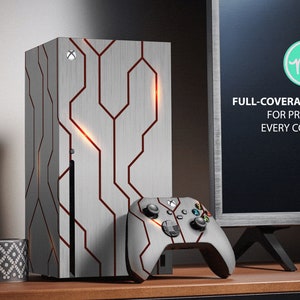 Puede incluir: Una piel con estampado geométrico blanco y rojo para una consola de juegos. La piel está diseñada para cubrir toda la consola, incluidos los rincones. La piel se muestra en una consola con un mando a juego. El texto en la pantalla dice "FULL-COVERAGE KIT FOR PROTECT EVERY CORNER".