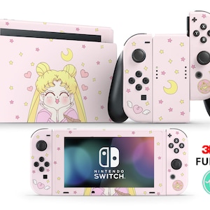 Peut inclure: Console et manettes Joy-Con Nintendo Switch roses avec un skin sur le thème de Sailor Moon. Le skin présente un fond rose avec des étoiles, des cœurs et un croissant de lune. Le personnage Sailor Moon est représenté au centre du skin de la console.