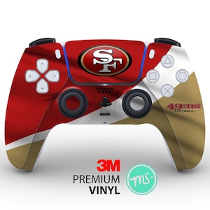 May include: A red, white, and gold PlayStation 5 controller with the San Francisco 49ers logo and "49ers Football" text. The controller has a 3M logo and the text "Premium Vinyl".