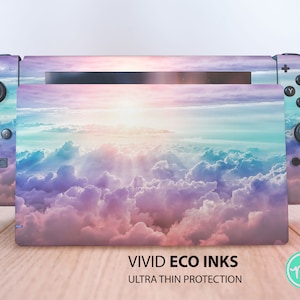 Könnte beinhalten: Eine farbenfrohe Nintendo Switch Konsolenhaut mit einem pastellfarbenen Himmel und Wolken. Die Haut ist so konzipiert, dass sie auf die Konsole und die Controller passt. Der Text "VIVID ECO INKS ULTRA THIN PROTECTION" ist unten auf dem Bild aufgedruckt.