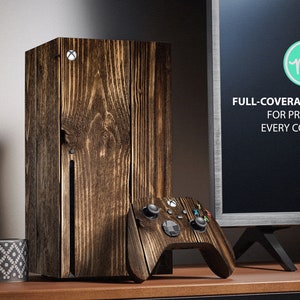 Könnte beinhalten: Eine Holzmaserung-Haut für eine Spielekonsole, mit einer passenden Haut für einen Controller. Die Haut ist ein Vollschutz-Kit, das alle Ecken schützt. Der Text auf dem Bildschirm lautet "FULL-COVERAGE KIT FOR PROTECT EVERY CORNER".