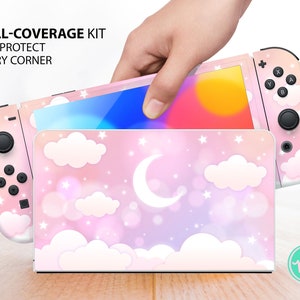 Può includere: Una skin per console Nintendo Switch rosa e bianca con un design a nuvole e luna. La skin è progettata per coprire l'intera console, inclusi i Joy-Cons. La skin è realizzata in vinile di alta qualità ed è facile da applicare e rimuovere. "FULL-COVERAGE KIT FOR PROTECT EVERY CORNER" è scritto sull'immagine.