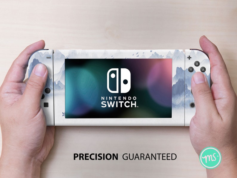 May include: A white Nintendo Switch console with a blue and white mountain landscape design. The console has the Nintendo Switch logo and the text "NINTENDO SWITCH." The text "PRECISION GUARANTEED" is printed below the console.