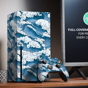 Peut inclure: Une peau de console de jeu à motif de vagues bleues et blanches. La peau couvre toute la console et comprend une peau assortie pour la manette. Le texte sur l'image indique "Kit de couverture complète pour protéger chaque coin".