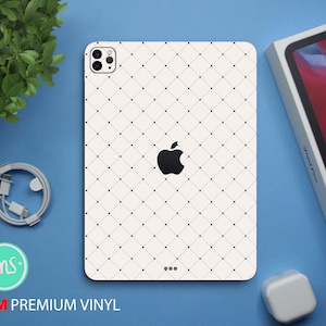 Puede incluir: Funda blanca para iPad Pro con un patrón geométrico blanco y negro. La funda tiene un recorte para el logotipo de Apple y la cámara.