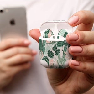 Op de afbeelding: Een witte Airpod-hoes met een groen en roze bloemenpatroon. De hoes is open en de Airpods zijn zichtbaar in de hoes.