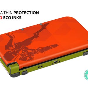 May include: Orange and green handheld gaming console skin with a graphic design. The skin features the text "ULTRA THIN PROTECTION" and "VIVID ECO INKS".