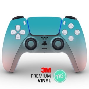 Puede incluir: Un mando de PlayStation 5 DualSense con un degradado de color turquesa y rosa, con el logotipo de 3M y el texto "PREMIUM VINYL" en la parte inferior.