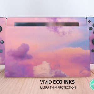 May include: A pink and purple Nintendo Switch console skin with a cloudy sky design. The skin is made by Vivid Eco Inks and features the text "Ultra Thin Protection".