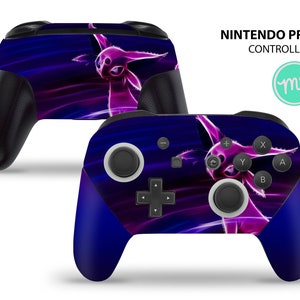 May include: A purple and blue Nintendo Pro Controller with a graphic of a pink Pokemon character. The controller has a black faceplate with buttons and a directional pad.