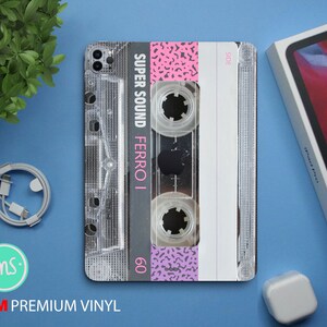 May include: A clear cassette tape with a pink and white design. The tape has the text "SUPER SOUND FERRO I 60" printed on it. The tape is labelled "SIDE A".