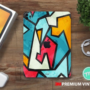 Może przedstawiać: Kolorowe etui na telefon z geometrycznym wzorem w odcieniach niebieskiego, czerwonego, żółtego i białego. Etui ma etykietę 3M Premium Vinyl.