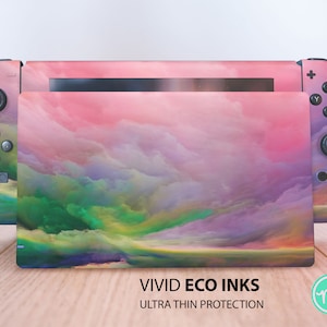 Könnte beinhalten: Eine farbenfrohe Nintendo Switch Konsolenhaut mit einem abstrakten Wolken-Design in Rosa, Grün und Lila. Die Haut trägt den Text "VIVID ECO INKS ULTRA THIN PROTECTION".
