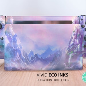 Puede incluir: Una piel para consola Nintendo Switch con un paisaje de montaña morado y azul y el texto "VIVID ECO INKS ULTRA THIN PROTECTION".