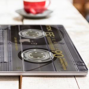 May include: A black and silver cassette tape with the text "STK EE FERIC 90" printed on the label. The tape is labeled "BEST TYPE I NORMAL POSITION" and "LOW NOISE HIGH OUTPUT".