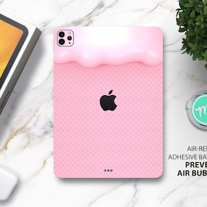 Op de afbeelding: Roze iPad-hoes met een wit en roze ijsdesign en een wafelpatroon. De hoes heeft een zwart Apple-logo en de tekst "AIR-RELEASE ADHESIVE BACKING PREVENTS AIR BUBBLES".
