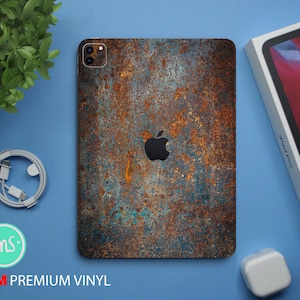 Könnte beinhalten: Eine Handyhülle mit einer rostigen Metalltextur in einem blauen und braunen Farbschema. Die Hülle hat einen Ausschnitt für das Apple-Logo und ein Kameraobjektiv.