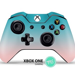 Puede incluir: Un mando Xbox One con un degradado de color turquesa y rosa, botones negros y un logotipo de Xbox negro. El mando est&aacute; sobre un fondo blanco con el texto "XBOX ONE GAMING" y un c&iacute;rculo verde con las letras "ms" en blanco.
