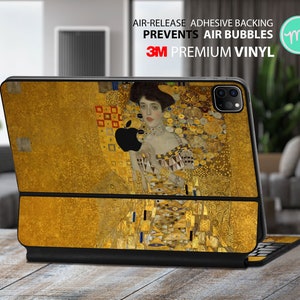 May include: A black tablet case with a gold and yellow design featuring a portrait of a woman holding an apple. The case has the text "AIR-RELEASE ADHESIVE BACKING PREVENTS AIR BUBBLES 3M PREMIUM VINYL".