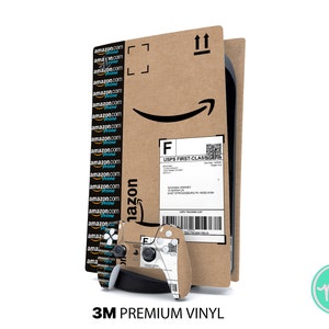 Könnte beinhalten: Ein brauner Karton mit einem weißen Etikett, auf dem "USPS FIRST-CLASS" und ein Barcode stehen. Der Karton hat ein schwarz-weißes Amazon-Logo auf der Vorderseite. Ein schwarz-weißer Videospiel-Controller ist teilweise auf der linken Seite des Kartons zu sehen. Der Text "3M PREMIUM VINYL" ist unter dem Karton gedruckt.