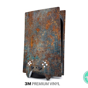 Könnte beinhalten: Ein rostiger Metallaufkleber für eine Playstation 5 Konsole. Der Aufkleber zeigt ein blaues und orangefarbenes rostiges Metallmuster. Der Aufkleber wird mit einem schwarzen Playstation 5 Controller gezeigt.