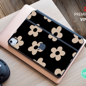 Könnte beinhalten: Eine schwarze iPad-Hülle mit einem 3M Premium Vinyl-Aufkleber mit einem sich wiederholenden Muster aus beigefarbenen Gänseblümchen.
