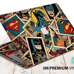 May include: Laptop skin featuring a collage of comic book panels with Batman, Superman, and other DC Comics characters. The design includes the Apple logo and the text "3M Premium Vinyl". The color palette includes blue, yellow, red, and black.