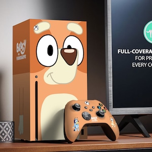 Könnte beinhalten: Ein Vollschutz-Skin-Decal für die Xbox Series X Konsole und den Controller mit einem Cartoon-Hund-Charakter aus dem Bluey the Videogame. Der Skin ist orange, braun und weiß mit einem Cartoon-Hund-Gesicht auf der Konsole und einem kleineren Cartoon-Hund-Gesicht auf dem Controller. Der Skin wurde entwickelt, um die Konsole und den Controller vor Kratzern und Abnutzung zu schützen.