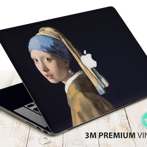 Könnte beinhalten: Eine Laptop-Haut mit einem Gemälde einer Frau mit einem blauen und gelben Kopftuch und einem Perlenohrring. Das Apple-Logo ist auf dem Laptop sichtbar.