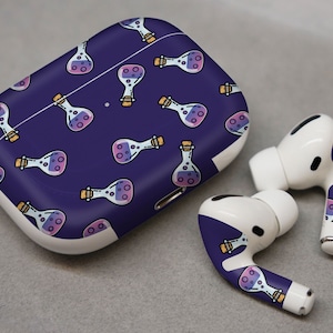 May include: A white wireless charging case for AirPods with a purple and pink potion design. The case has a lid and a bottom section. The case is shown with two white wireless earbuds with the same potion design.