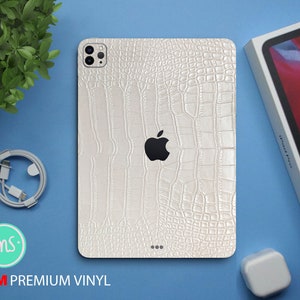 Op de afbeelding: Witte iPhone-hoes met een krokodilleerpatroon en een 3M Premium Vinyl-logo. De hoes heeft een uitsparing voor de cameralens en een wit Apple-logo.