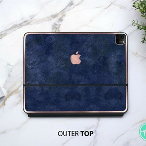 May include: A navy blue leather case with a rose gold trim for an iPad or tablet. The case has a textured surface and features the Apple logo in the top section.