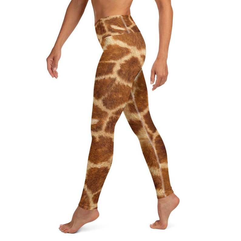 May include: High-waisted yoga leggings with a giraffe print. The leggings feature a brown and tan pattern, mimicking the distinctive markings of a giraffe. The leggings are form-fitting and designed for athletic activities.