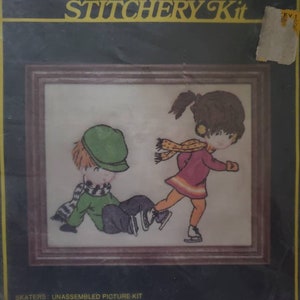 May include: A cross-stitch kit featuring two children ice skating. The kit includes a pre-printed design on homespun fabric, acrylic yarn, embroidery thread, and a needle. The kit is for a 5 1/2 inch by 6 1/2 inch frame. The kit is labeled "Skaters: Unassembled Picture Kit" and "Crewel Creative Stitchery Kit".