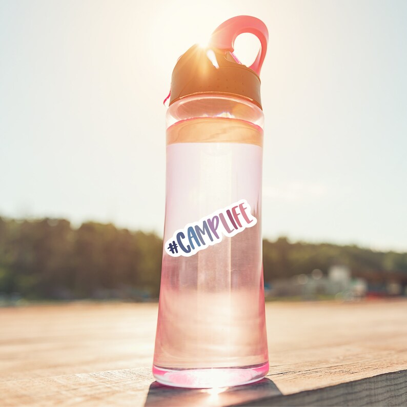 May include: A pink and clear water bottle with a black lid and a sticker that says "#CAMPLIFE".