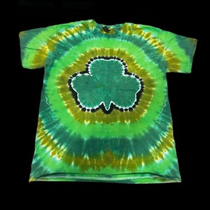 May include: Green, yellow and black tie-dye t-shirt with a large shamrock design in the centre.