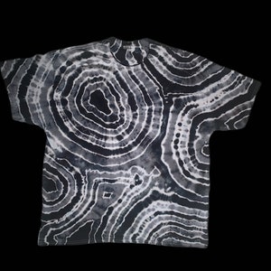 May include: Black and white tie-dye t-shirt with a circular pattern.