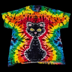 May include: A tie-dye t-shirt with a black cat design in the center. The shirt is a rainbow of colors, including red, orange, yellow, green, blue, and purple.