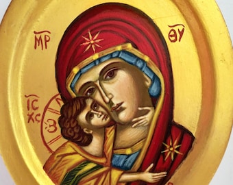 May include: A hand-painted icon of the Virgin Mary and baby Jesus. The icon is painted on a wooden panel with a gold background. The Virgin Mary is wearing a red robe and a blue veil. The baby Jesus is wearing a yellow robe. The icon is dated "X.2020".