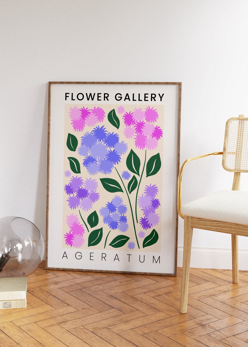 May include: A framed print with a floral design featuring purple and pink flowers with green leaves. The print has the text "FLOWER GALLERY" and "AGERATUM" in black.