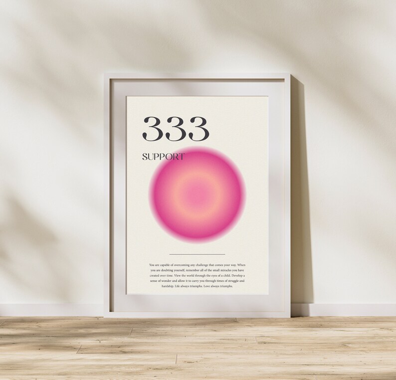 May include: A white framed poster with a pink and yellow gradient circle in the center. The number 333 and the word "SUPPORT" are printed in black at the top of the poster. The text below the circle reads: "You are capable of overcoming any challenge that comes your way. When you are doubting yourself, remember all of the small miracles you have created over time. View the world through the eyes of a child. Develop a sense of wonder and allow it to carry you through times of struggle and hardship. Life always triumphs. Love always triumphs."