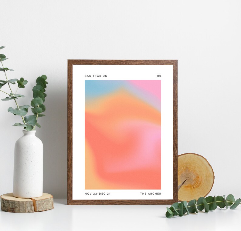Może przedstawiać: Wydruk w ramie z gradientowym tłem w odcieniach r&oacute;żowego, pomarańczowego i niebieskiego. Tekst "Sagittarius" znajduje się u g&oacute;ry wydruku, wraz z liczbą "09". Tekst "Nov 22-Dec 21" i "The Archer" znajduje się u dołu wydruku.