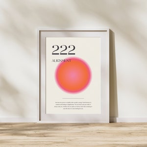May include: A white framed poster with the number 222 and the word "ALIGNMENT" in black text. A large pink and orange circle is in the center of the poster. The text below the circle reads: "You have the power to amplify other people's energy! Find harmony in contrast and healing in togetherness. You are loved, and your other is always with you, whether they be spirits or humans. Seek what is lacking in your life since it is also looking for you."