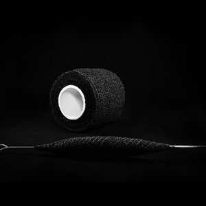 May include: A roll of black athletic tape and a black metal tool with a loop at one end.